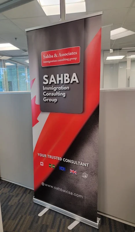 Roll-up banner for Sahba Immigration Consulting Group featuring Canadian flag design and global visa services