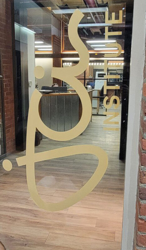 Custom window stickers installed on a retail storefront in Vancouver, showcasing promotional messages with bold vinyl graphics.