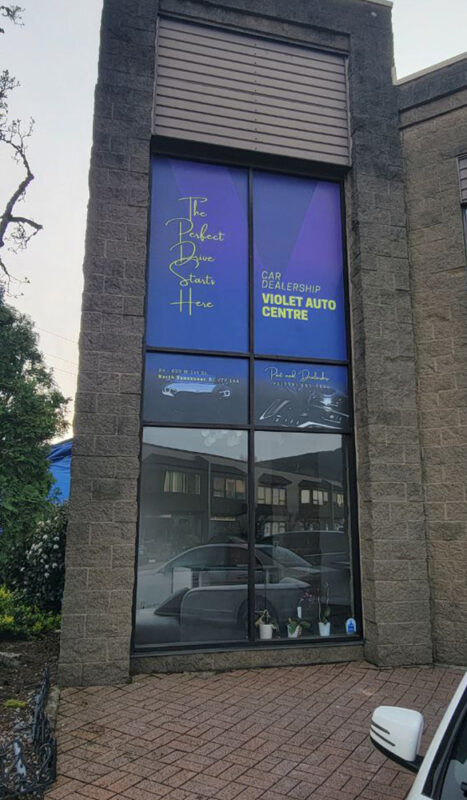Custom-designed window decals featuring business hours and branding applied to a salon window.